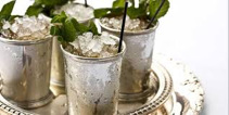 Refreshing mint juleps with crushed ice in silver cups.