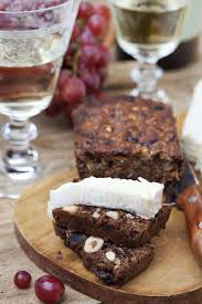 Sliced nut bread with creamy cheese on a wooden board.