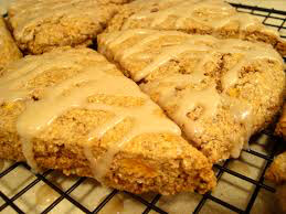 Golden-brown scones with a drizzle of icing on top.