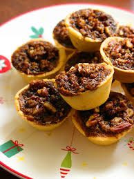 Close-up of pecan pie mini tarts on a festive plate.