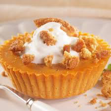 A pumpkin tart topped with whipped cream and crumbled topping.