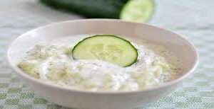 Creamy cucumber yogurt dip garnished with a cucumber slice.