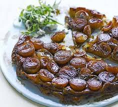 Caramelized onion tart with a savory glaze on a white plate.