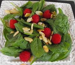 Fresh spinach salad with raspberries and almond slices.