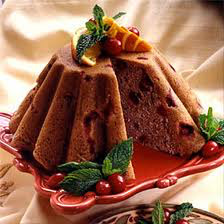 A slice of fruit-studded cake garnished with mint and berries.
