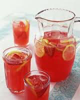 Pitcher and glasses of iced tea with lemon slices on a table.