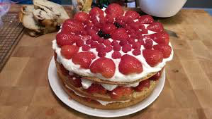 A layered strawberry cake with whipped cream topping.