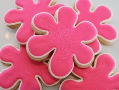 Pink flower-shaped cookies with smooth icing.