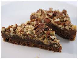 Two slices of nut-topped chocolate dessert bars.