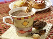 A cup of hot chocolate with cinnamon sticks and spices.