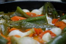 Close-up of cooked okra and vegetables in a dish.