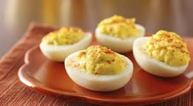 Close-up of deviled eggs on a wooden plate.