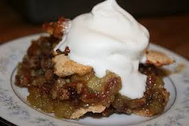 A slice of pecan pie topped with whipped cream.