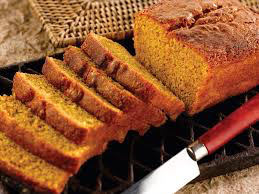 Sliced pumpkin bread loaf with a knife beside it.