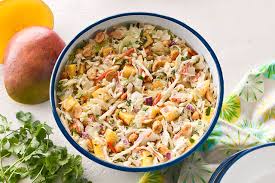 A bowl of colorful pasta salad with vegetables and dressing.