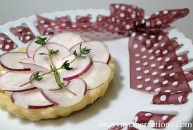 A tart topped with radish slices and thyme sprigs.