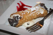 A delicious cannoli dessert topped with powdered sugar and chocolate chips.