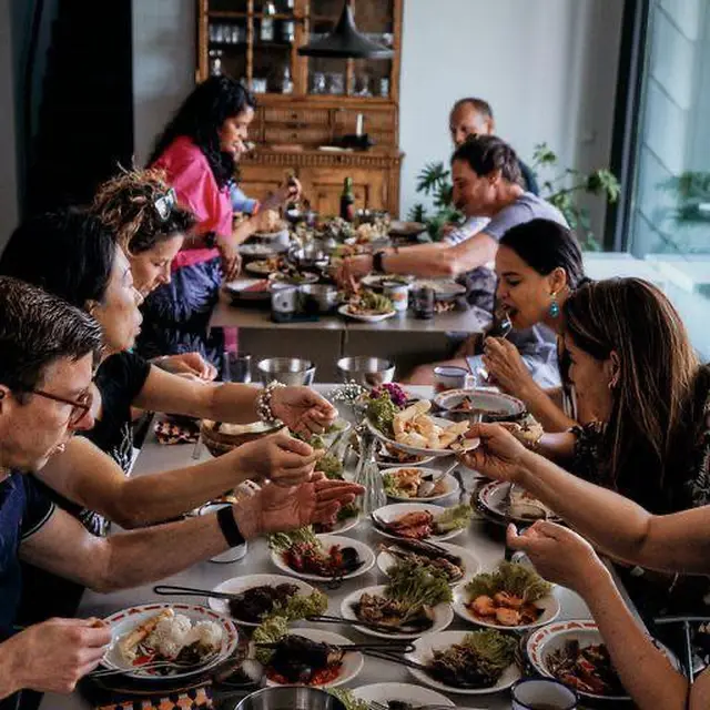 People enjoying a communal meal at a long table.
