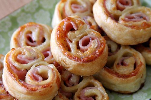 Close-up of freshly baked ham and cheese pinwheel pastries.