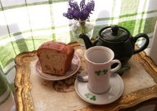 A cozy tea setup with a slice of cake and a teapot.