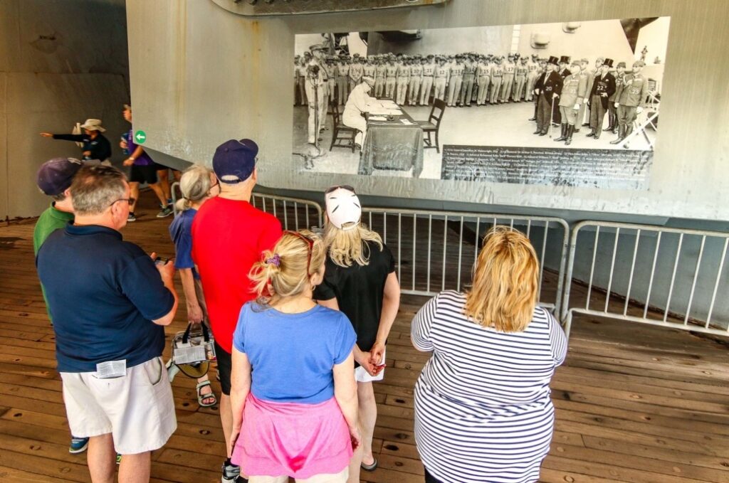 People observing a historical black-and-white photo exhibit.
