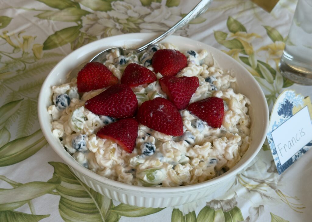 Bowl of cottage cheese topped with strawberries and blueberries.