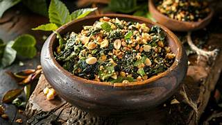 A bowl of leafy green salad topped with nuts and seeds.