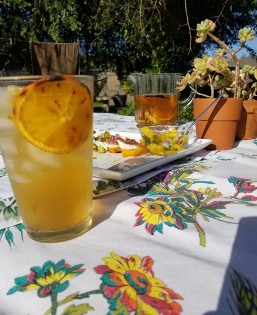 Iced drinks on floral table outdoors.