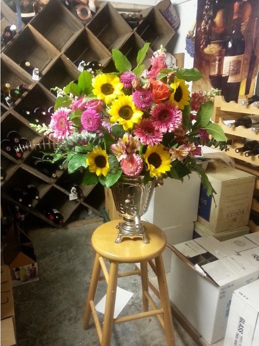 Vibrant flower bouquet on wooden stool.