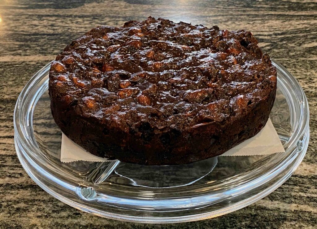 Rich fruitcake on a glass stand.